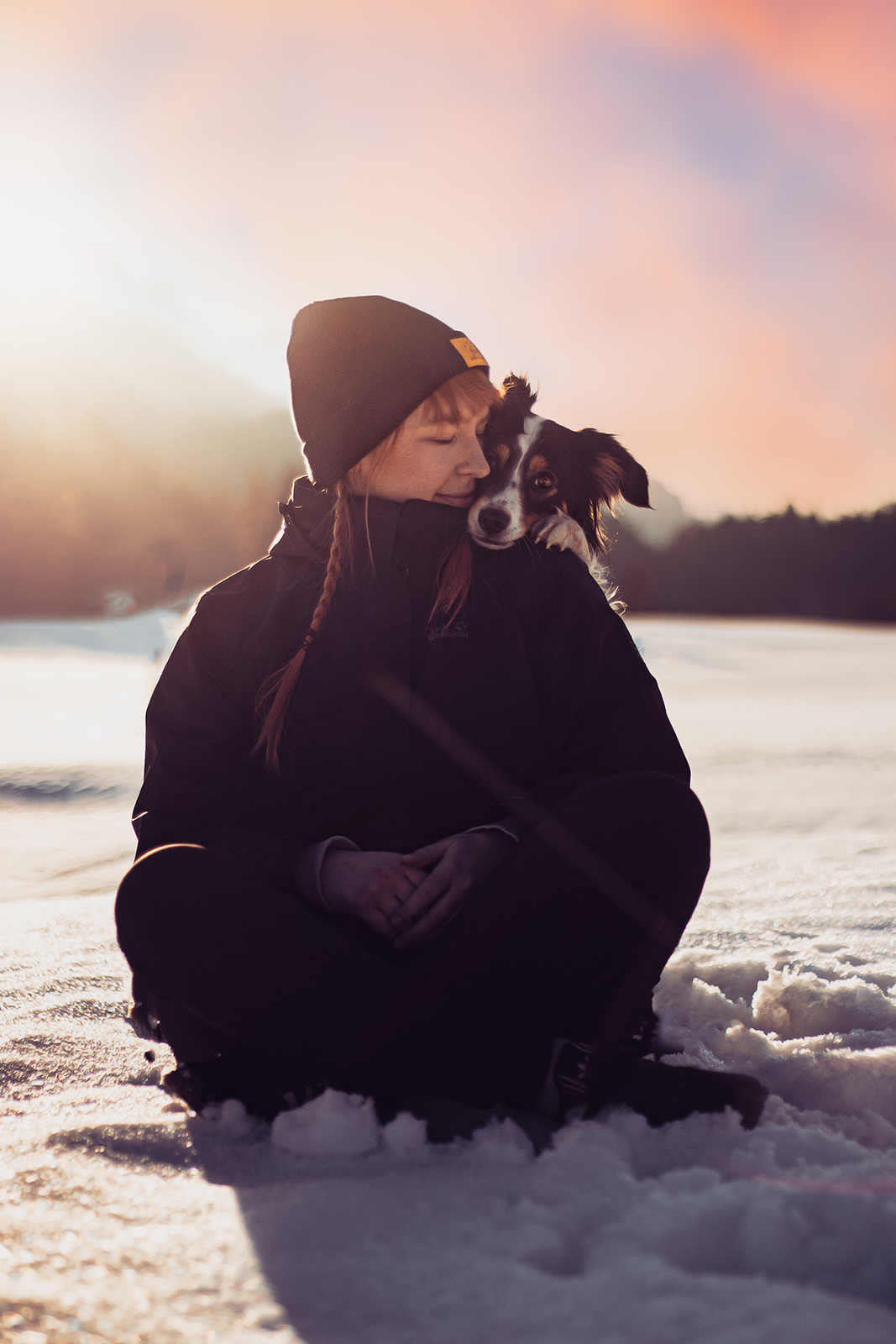 Pia Fotografin sitzt mit Hund im Schnee
