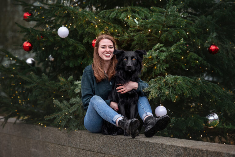 Frau und Hund vor Weihnachtsbaum